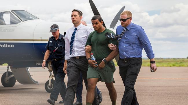 Jermaine Austral is escorted by police upon his return to Alice Springs. Photo: Emma Murray