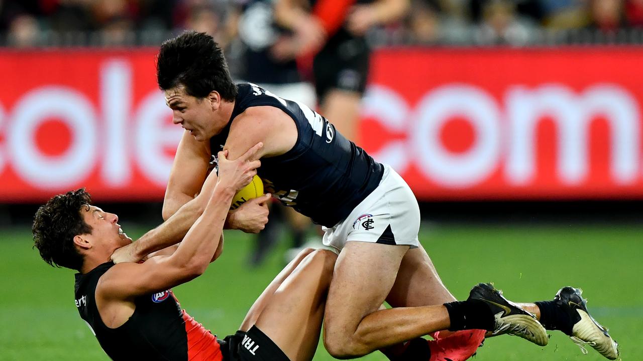 MELBOURNE, AUSTRALIA - JUNE 09: Elijah Hollands of the Blues is tackled by Jye Caldwell of the Bombers during the round 13 AFL match between Essendon Bombers and Carlton Blues at Melbourne Cricket Ground, on June 09, 2024, in Melbourne, Australia. (Photo by Josh Chadwick/Getty Images)