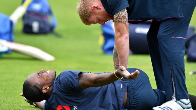 England's Ben Stokes (right) helps teammate Jofra Archer stretch yesterday. Picture: AFP