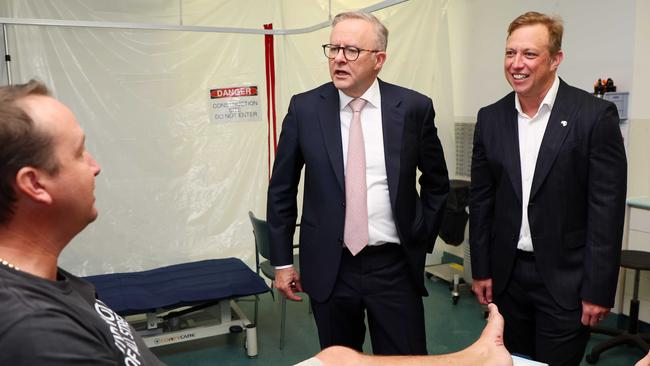 Anthony Albanese and Steven Miles speak to Luke Vervoorn, who was injured rescuing a cow during the floods, during a visit to the Murrumba Downs Medical and Dental Centre. Picture: Tertius Pickard