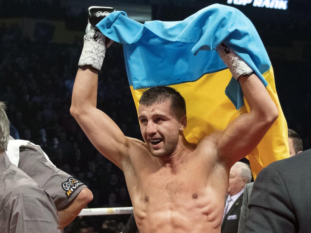 Oleksandr Gvozdyk raises the Ukrainian flag after his WBC light heavyweight win.