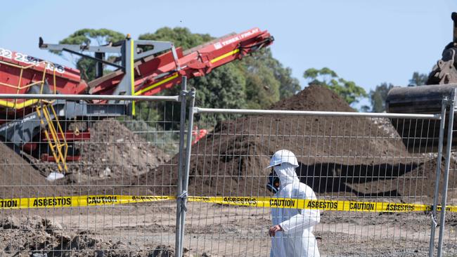 In March, workers in protective equipment move contaminated soil with asbestos signs around the building site in Murray Rd, Queenscliff. Picture: Brad Fleet