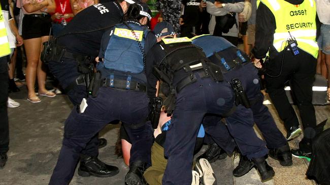 Gold Coast police making an arrest at last year’s Schoolies festival. Picture: AAP/David Clark