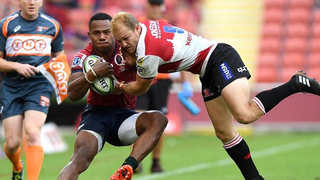 The Reds’ Filipo Daugunu of the Reds tries to beat the Lions’ Dillon Smit on Saturday.