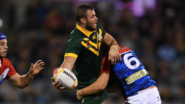 Wade Graham of the Kangaroos (centre) passes a ball as he is tackled by Remy Marginet of France during the Rugby League World Cup Group A match between France and Australia at GIO Stadium in Canberra, Friday, November 3, 2017. (AAP Image/Lukas Coch) NO ARCHIVING, EDITORIAL USE ONLY