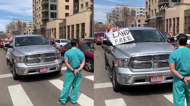 Counter-protesters in scrubs block anti-lockdown campaigners in Denver