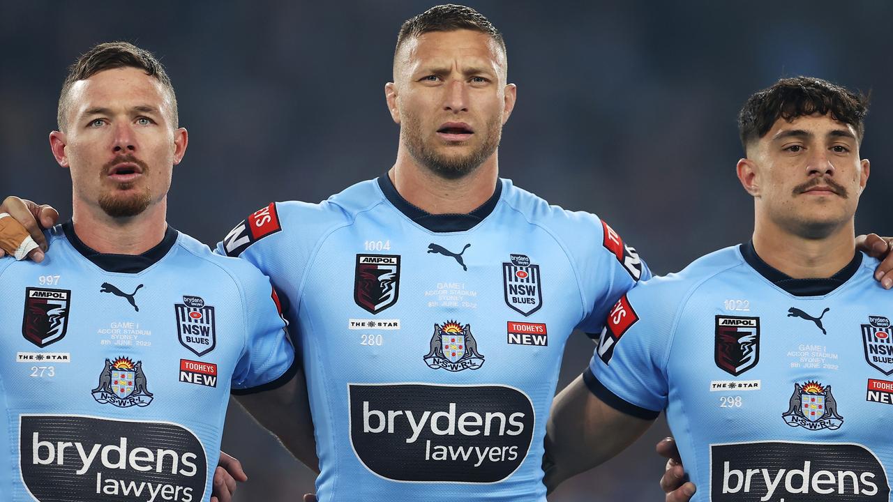 SYDNEY, AUSTRALIA - JUNE 08: Damien Cook, Tariq Sims and Kotoni Staggs of the Blues stand for the national anthem before game one of the 2022 State of Origin series between the New South Wales Blues and the Queensland Maroons at Accor Stadium on June 08, 2022, in Sydney, Australia. (Photo by Mark Kolbe/Getty Images)