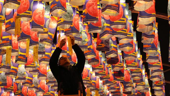 A man hangs a wish ribbon at a lantern show in preparation for the Chinese New Year. Picture: Getty Images