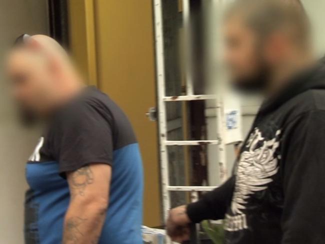 Arrests ... Two men are led away for questioning. Photo: NSW Police