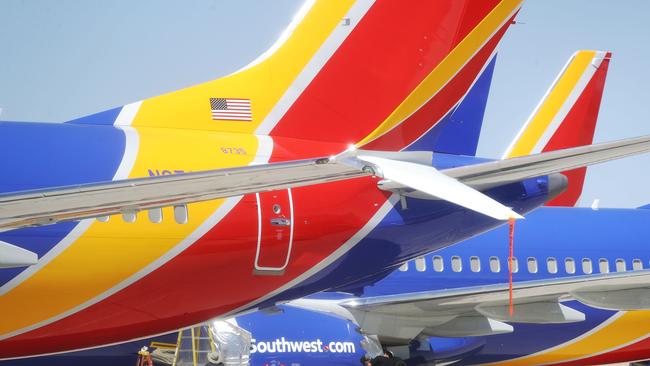 VICTORVILLE, CA - MARCH 27: Workers stand beneath Southwest Airlines Boeing 737 MAX aircraft parked at Southern California Logistics Airport on March 27, 2019 in Victorville, California. Southwest Airlines is waiting out a global grounding of MAX 8 and MAX 9 aircraft at the airport.   Mario Tama/Getty Images/AFP == FOR NEWSPAPERS, INTERNET, TELCOS & TELEVISION USE ONLY ==