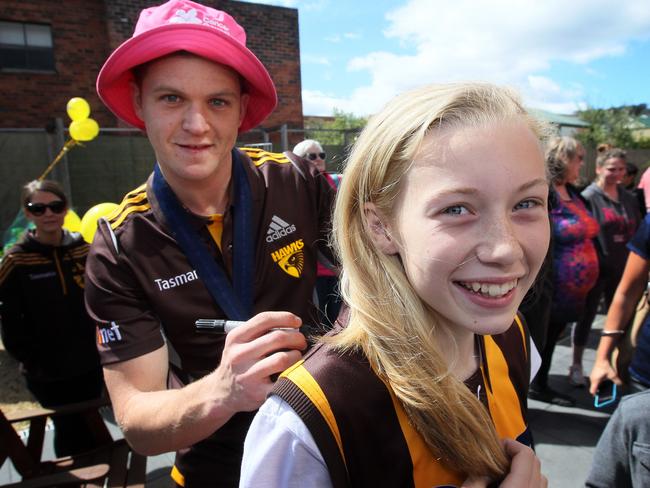 Hawthorn’s Taylor Duryea signs Maggie Ralph’s top in Launceston. Picture: ROSS MARSDEN