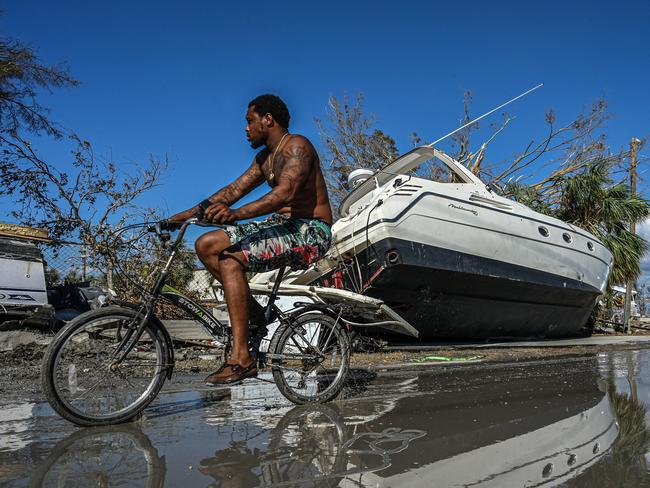 A man cycles past a boat in the aftermath of Hurricane Ian in San Carlos Island, Florida. Picture: AFP