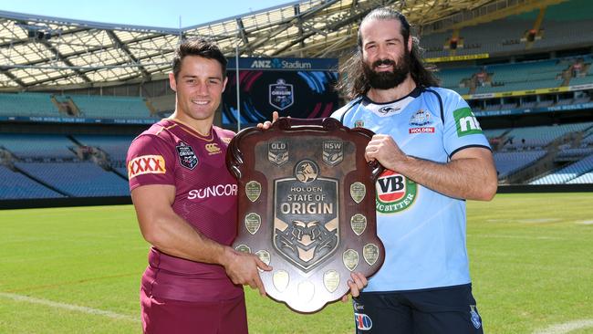 Maroons star Cooper Cronk Blues gun Aaron Woods pose with the State of Origin shield earlier this year.