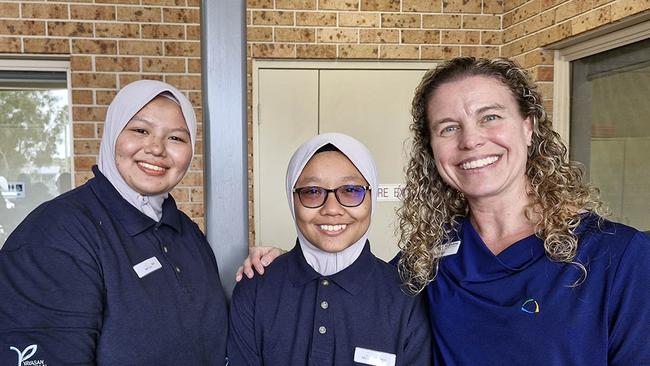 Students Nik Azra Syazwani Binti Nik Ismail and Nur Iszatee Binti Ismail with Heather Kitching, trainer at NV College, Nambucca.