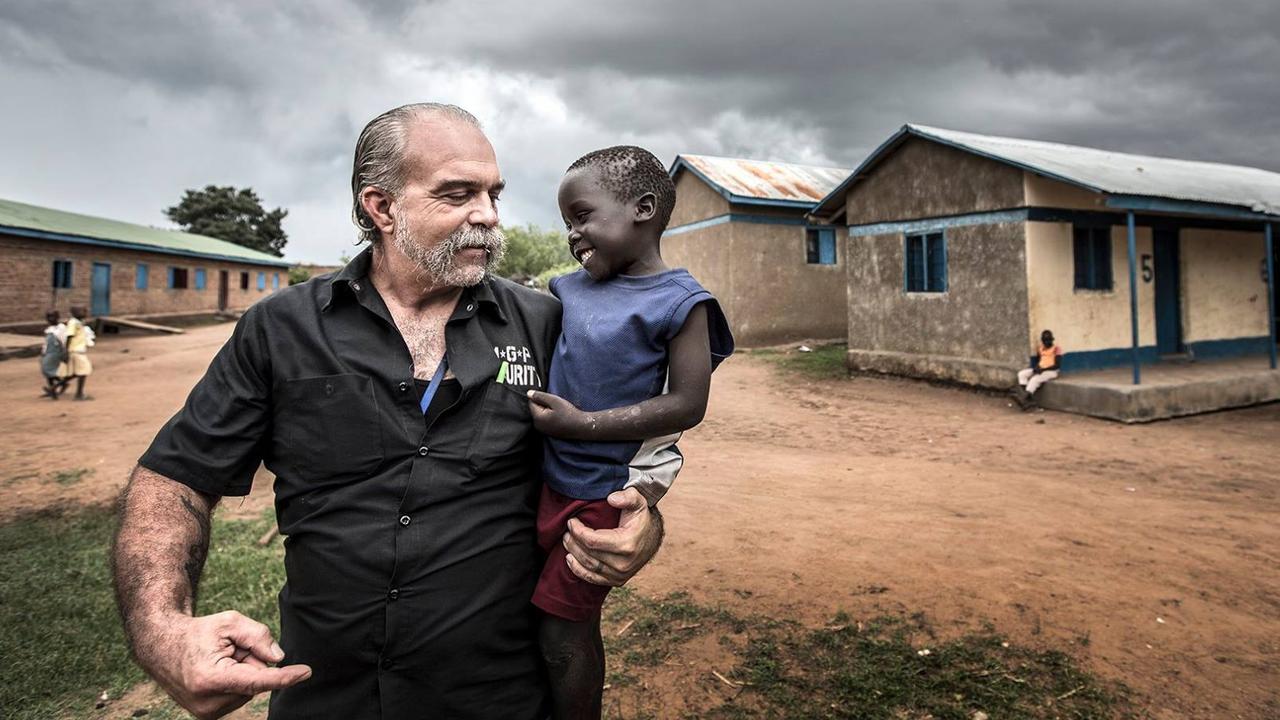 Sam Childers with an orphan in Nimule, South Sudan. Picture: Contributed