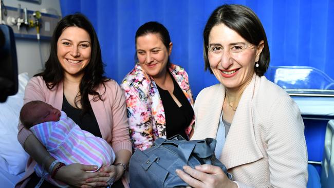 NSW Premier Gladys Berejiklian and Member for Holsworthy Melanie Gibbons mother Rose Raketic and her newborn daughter Isidora receiving a baby bundle. Picture: AAP Image/Joel Carrett