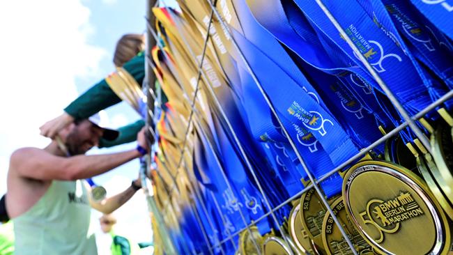 A runner is given a medal after finishing the 50th edition of the Berlin Marathon in Berlin. Picture: John Macdougall / AFP