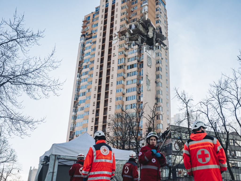 Emergency services in front of the bombed civilian building in a residential area in Kyiv.