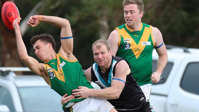 Leongatha’s Jake van der Pligt tries to handball the ball away from a tackle. Picture Yuri Kouzmin