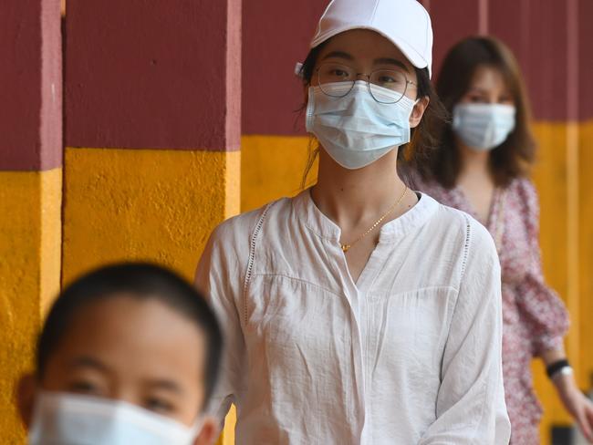 TOPSHOT - Chinese tourists wearing protective masks to help stop the spread of a deadly virus which began in Wuhan, look on at a train station in Colombo on January 28, 2020. - China's capital on January 27 recorded its first death from a deadly coronavirus as it struggles to contain a rapidly spreading disease that has sparked global alarm, with countries scrambling to evacuate their citizens from the epicentre of the epidemic. (Photo by LAKRUWAN WANNIARACHCHI / AFP)