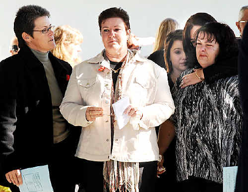 Stan Tilley’s only daughter, Karen Pound (second from left) is comforted by family and friends following the church service.