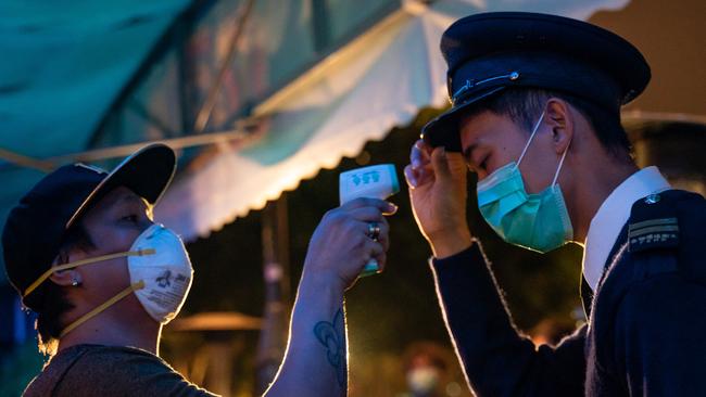 A police officer has his body temperature measured in Hong Kong. Picture: Getty Images