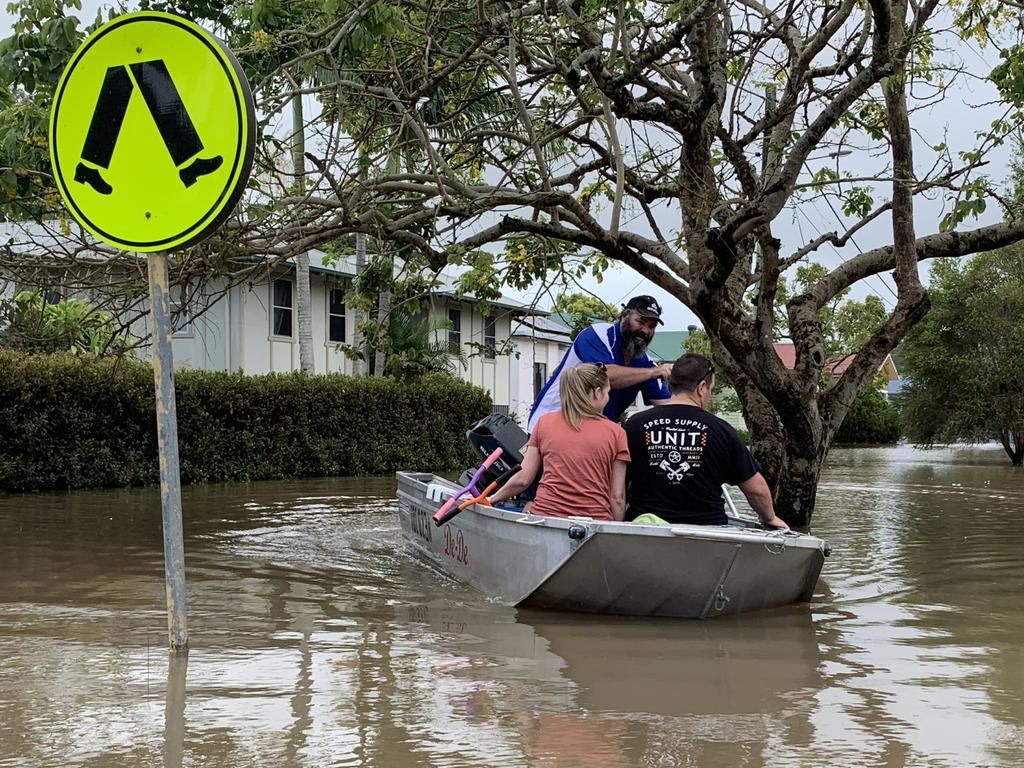 Max Walker paddles for Steve and Bianca Bennett after taking them to their flooded Hunter Street home on March 1, 2022, a day after Lismore was hit by a record flood. Picture: Stuart Cumming