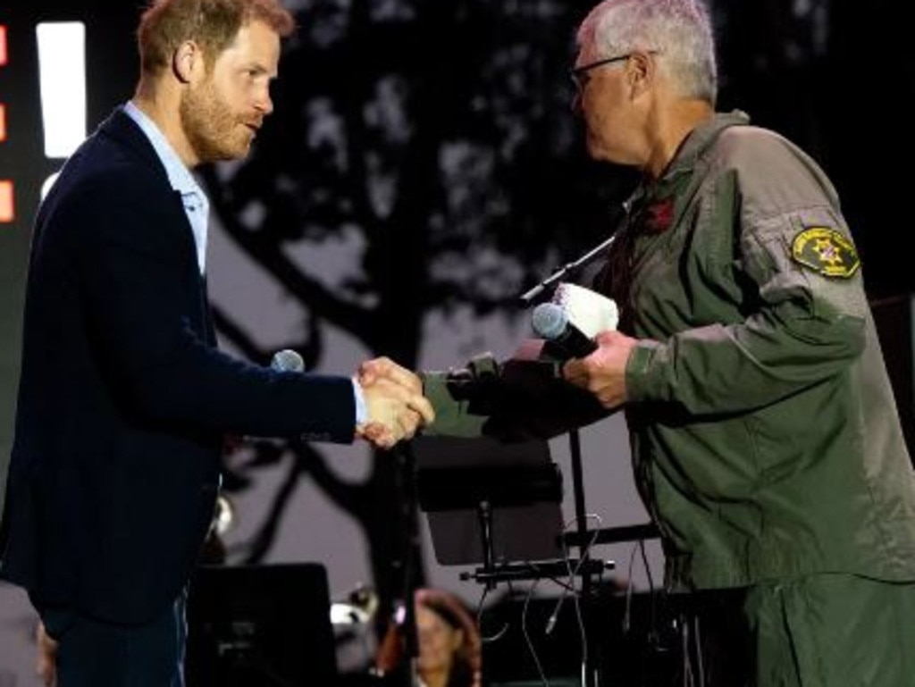 Prince Harry with helicopter pilot Loren Courtney. Picture: Getty Images