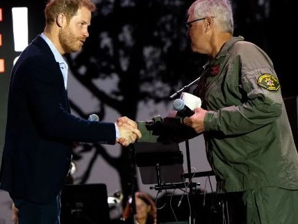 Prince Harry with helicopter pilot Loren Courtney. Picture: Getty Images