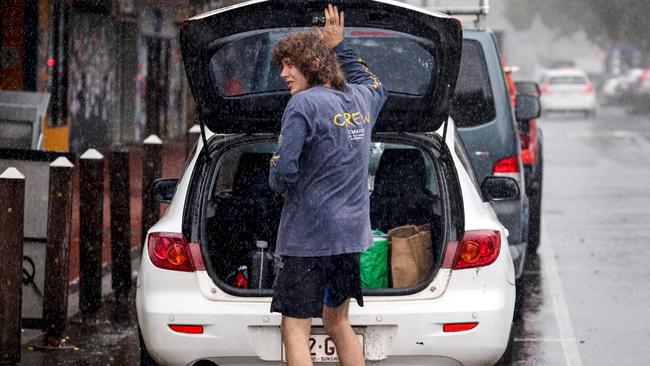 A resident packs a car of stock from a shop in the town of Lismore on March 5, 2025. A rare tropical cyclone veered towards Australia's densely populated eastern coast on March 5, forcing scores of schools to close as worried residents stripped supermarket shelves bare. (Photo by DAVID GRAY / AFP)