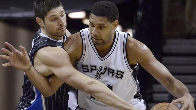 Orlando Magic centre Nikola Vucevic, left, defends San Antonio Spurs forward Tim Duncan.