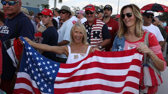 ESTERO, FL - OCTOBER 31: Two women hold an American flag as people stand in line for President Donald Trump's campaign rally at the Hertz Arena on October 31, 2018 in Estero, Florida. President Trump continues travelling across America to help get the vote out for Republican candidates ahead of the midterm elections.   Joe Raedle/Getty Images/AFP == FOR NEWSPAPERS, INTERNET, TELCOS & TELEVISION USE ONLY ==