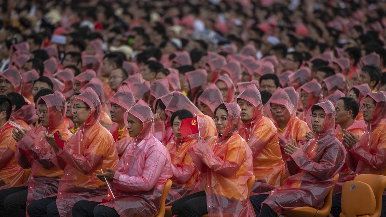 Members of the audience wear raincoats as they listen to a speech by Chinese President Xi Jinping at a ceremony marking the 100th anniversary of the Communist Party. Picture: Kevin Frayer/Getty Images