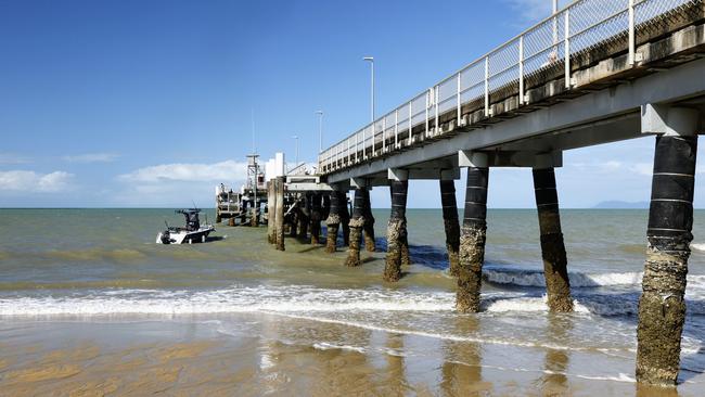 The lowest tide of the year has seen a lot of sand exposed on Palm Cove beach and left the jetty pylons high and dry. Picture: Brendan Radke