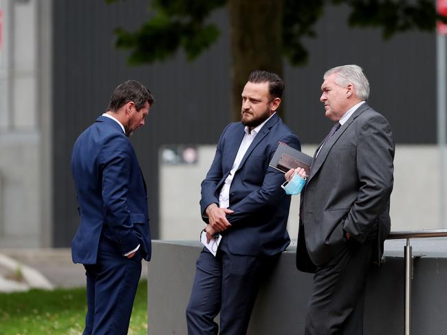 Mr Deger centre talking with his solicitor Ryan Finch (left) and another man (right). Picture: Sue Graham