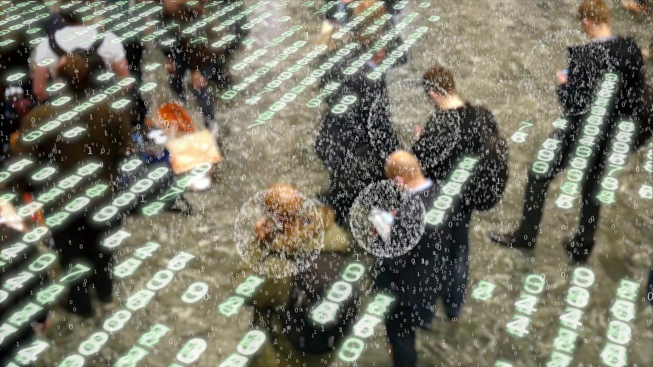 Stylized visualization of binary data being emitted by people waiting in a crowd and using their phones. istock