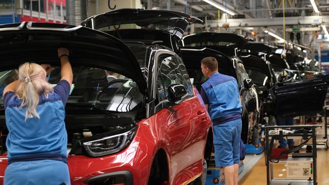 Workers assemble BMW I3 electric cars on an assembly line at the BMW factory in Leipzig, Germany. Picture: Getty