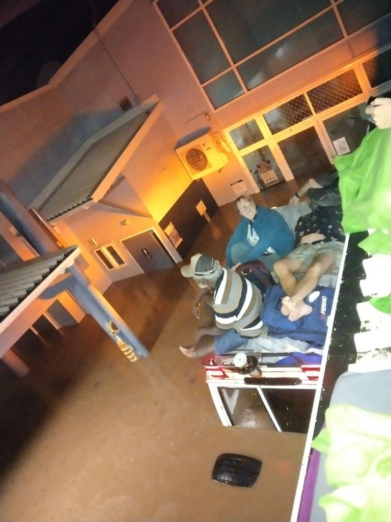 Stranded residents sit on top of a car in flood waters. Picture: Wujal Wujal Health Clinic