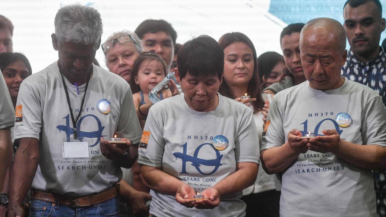 Relatives hold candles during an event to mark the 10th year since the Malaysia Airlines flight MH370 carrying 239 people disappeared in 2014 while en route from Kuala Lumpur to Beijing. Pictured on March 3, 2024. (Photo by Arif Kartono / AFP)