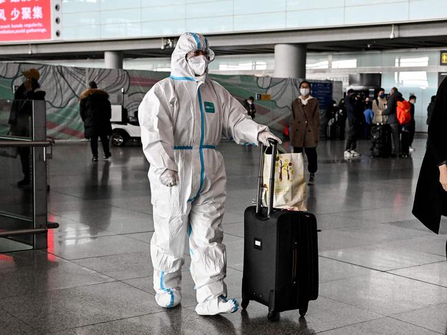 A passenger wearing personal protective equipment arrives at Beijing Airport. Picture: AFP