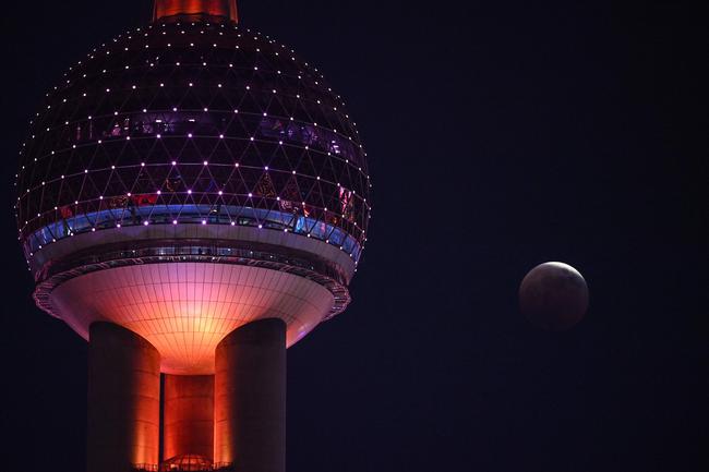 The 'Blood Moon' is seen from The Bund promenade during a total lunar eclipse in Shanghai. Picture: Hector RETAMAL / AFP