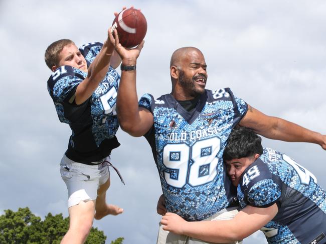 Noah Parker,who once played Grid Iron in college with Tom Brady, finds out about NFL australian style as a shoeless Jaylan Amor 17 and Kobi Rayner 16 set out to bring down the giant american during a training session with students from Men of Business Academy at Broadwater Parklands. Picture Glenn Hampson