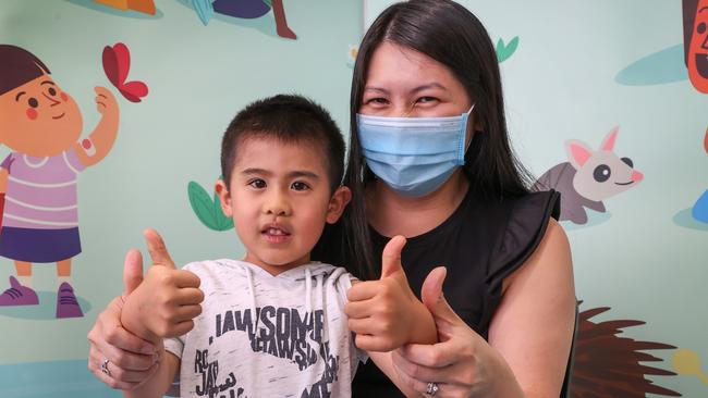 Lincoln 5, sits on his mother’s lap to receive his first vaccination. Picture: David Caird