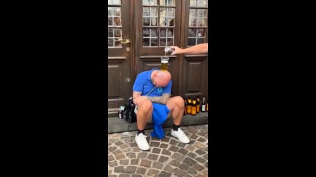 Blokes use a passed out man for a drinking game