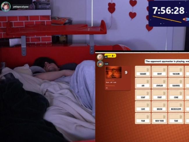 Twitch streamer Ludwig (left) sleeps on camera on Monday during his marathon broadcast. In the foreground, stream moderators play a game to keep viewers entertained