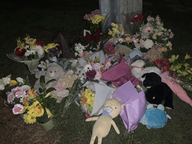 Mourners have placed flowers and toys at a makeshift memorial in Raven St, Camp Hill.