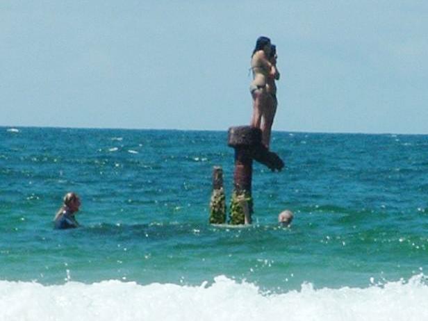 MUST CREDIT: Northern Star... Girls Caitlin Robinson and Jett Coates (both 14) standing on rusty shipwreck about 50 metres off Main Beach at Byron Bay as surfers come to their aid. They were forced to wait for rescue when they saw sharks circling them after they has swum out to the wreck. Picture: Star Northern