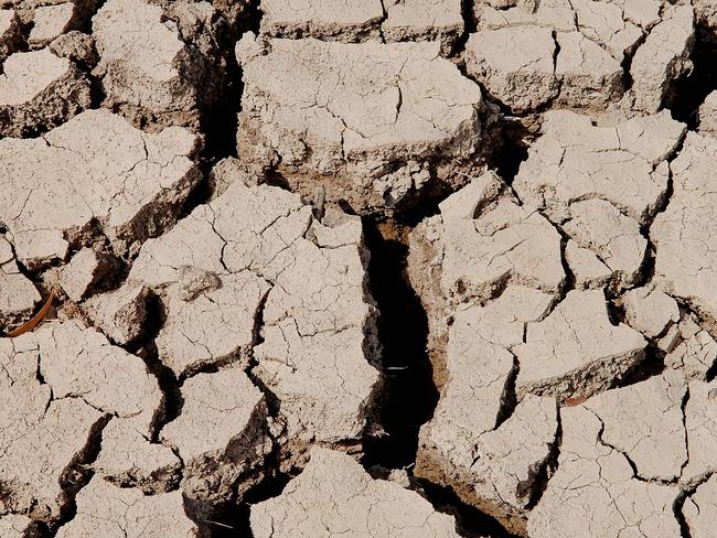 cracks line the bottom of a farmers dam in Cootamundra. 14/12/06. Story: Bev Jordan. Picture: BRADEN FASTIER drought dry mud