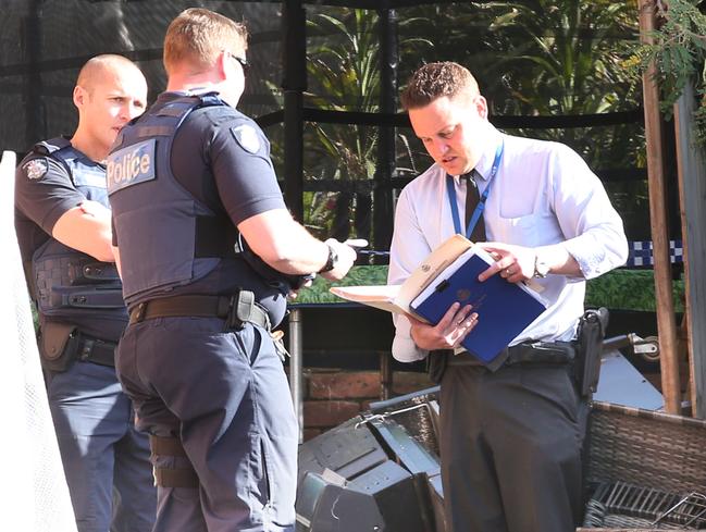 Police stand next to what appears to be balcony furniture as they investigate the collapse. Picture: David Crosling.