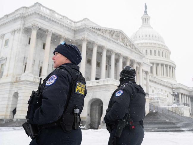 US Capitol Police officers stand watch outside the US Capitol building as snow falls ahead of a joint session of Congress to certify the results of the 2024 Presidential election on January 6, 2025, in Washington, DC. Exactly four years after Donald Trump's supporters stormed the US Capitol, seeking to overturn his election loss, lawmakers meet today to certify his 2024 Presidential win, cementing the Republican's comeback from political ignominy. (Photo by SAUL LOEB / AFP)